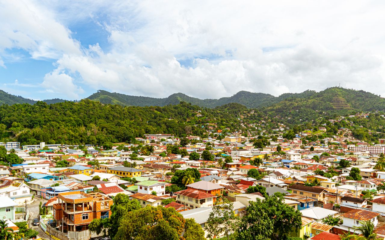 Vibrant aerial view of Port of Spain with green mountains and blue sky, Trinidad and Tobago.